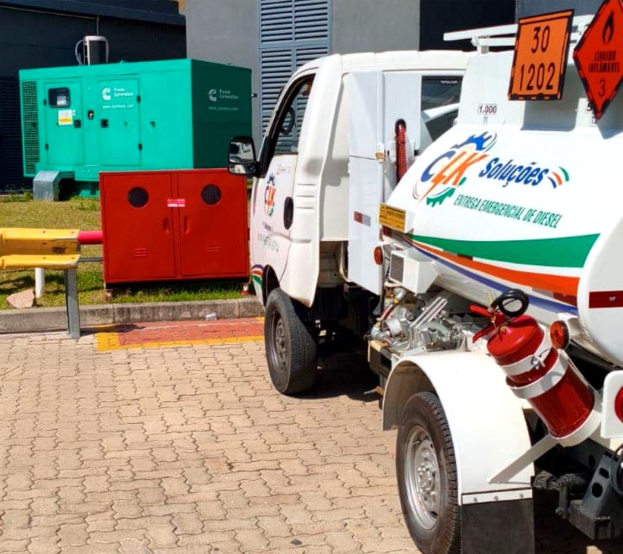 Caminhão-tanque de diesel da CLK Soluções ao lado de gerador Cummins em pátio de empresa